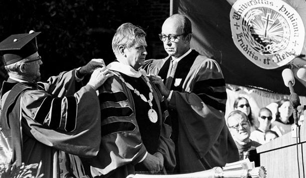 Two white men hang a medal on another white man